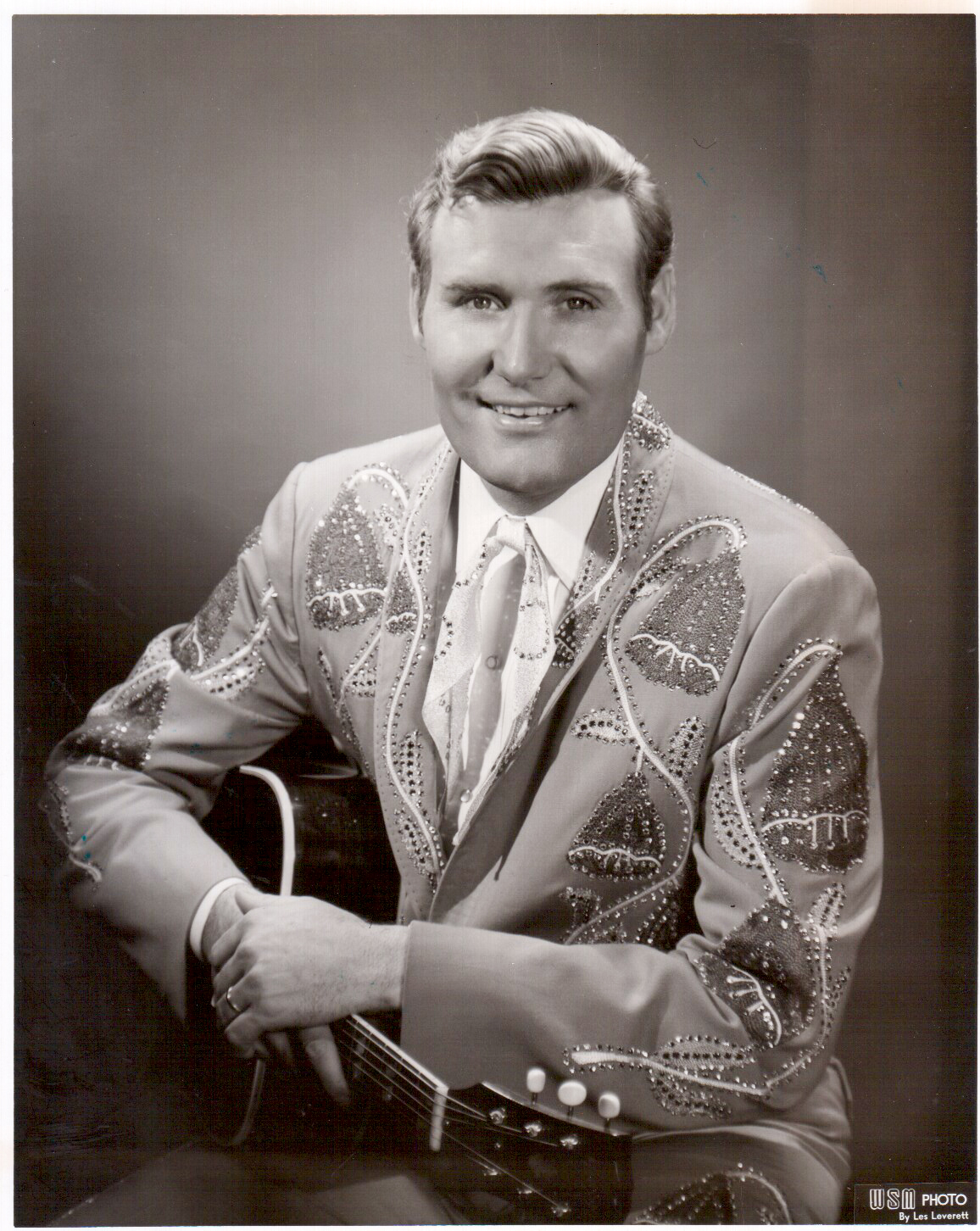 Billy Walker in an embroidered suit, seated with guitar